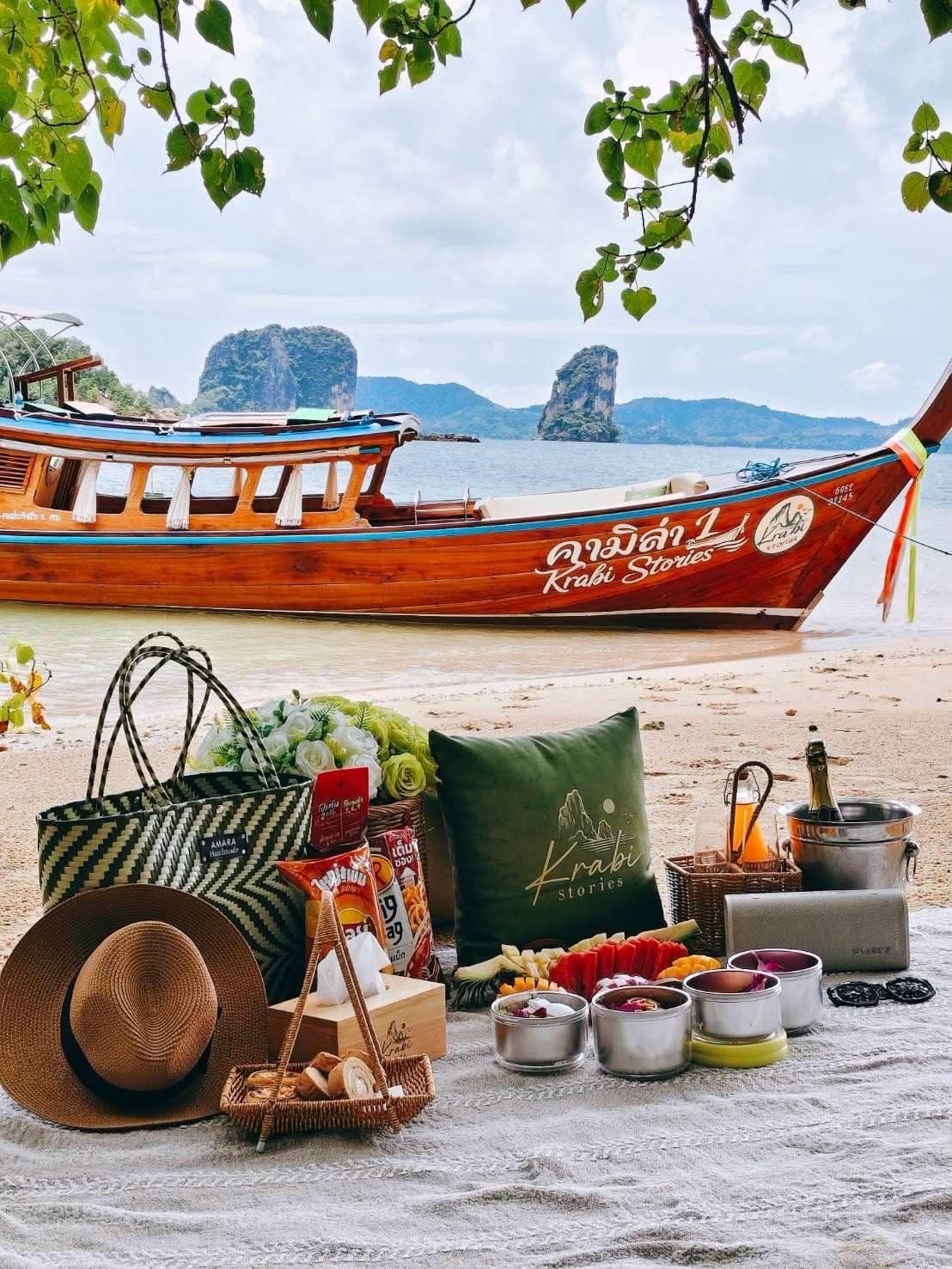 Krabi Stories longtail moored off the beach with the picnic laid out under the trees