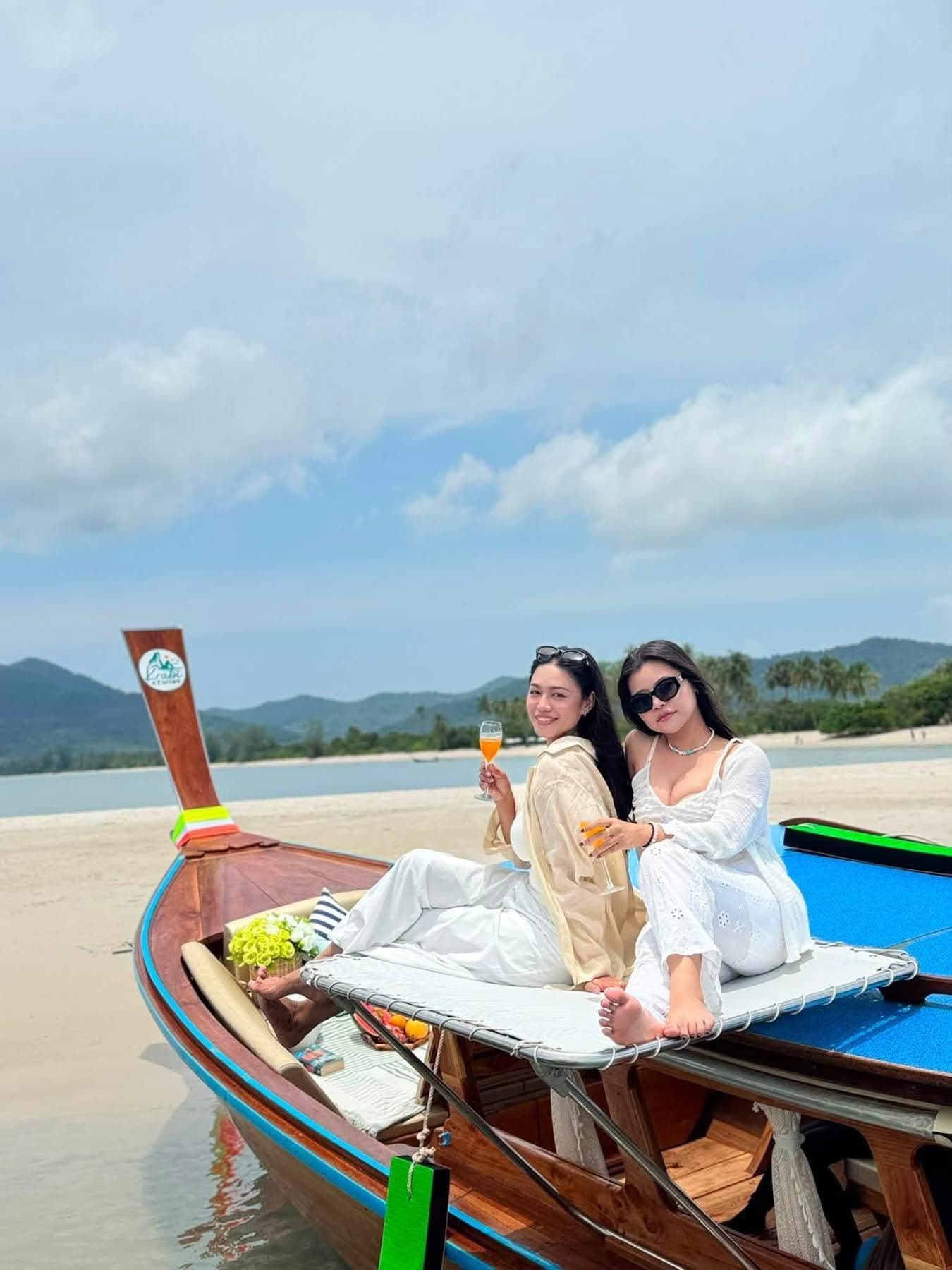 Guests relaxing on the bow of the boat at a quiet beach