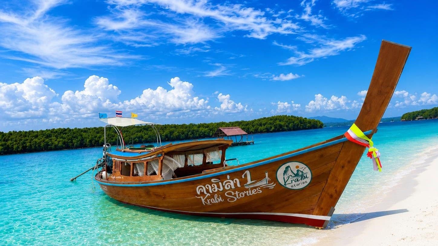 Krabi Stories longtail boat moored at a white-sand beach with turquoise water